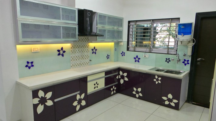 An ugly retro kitchen with flowers painted on the backsplash and cabinets.