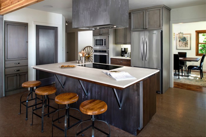 A kitchen with dark grey cabinets and a light-colored kitchen island made of Dekton.