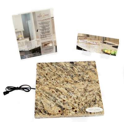 sample size stone countertop cutout connected to FeelsWarm heating pad next to company brochure