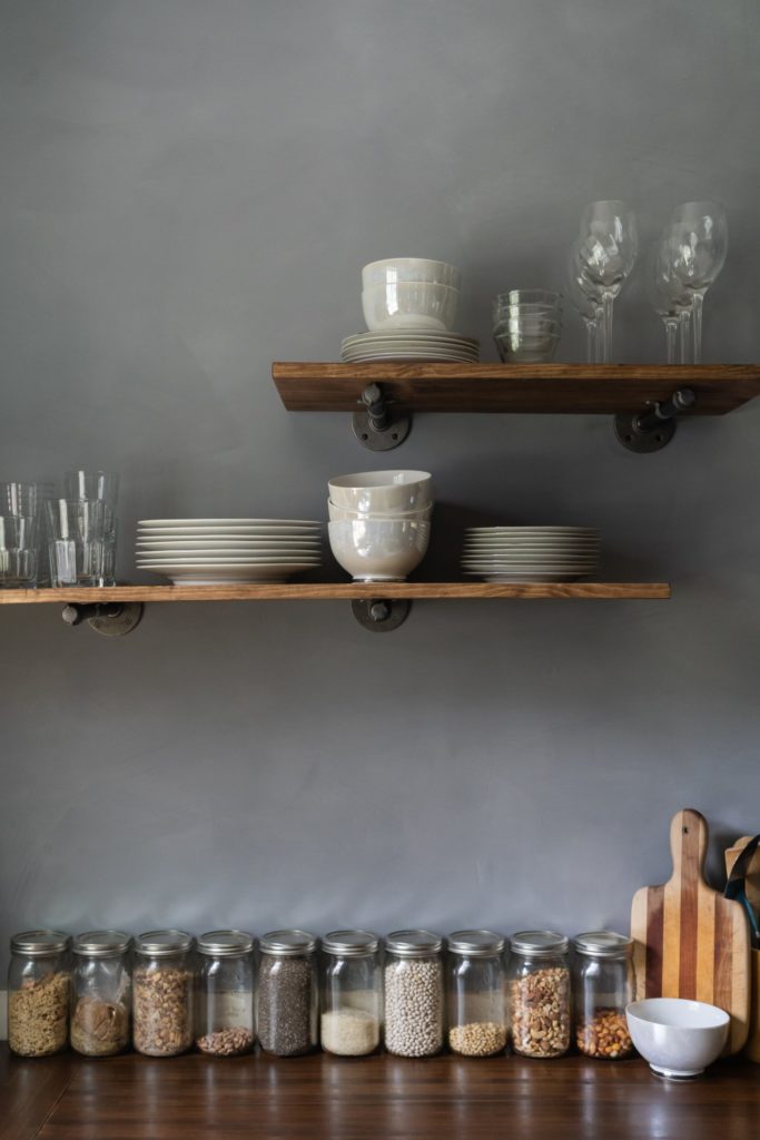 Floating shelves stacked with dishes in an industrial kitchen