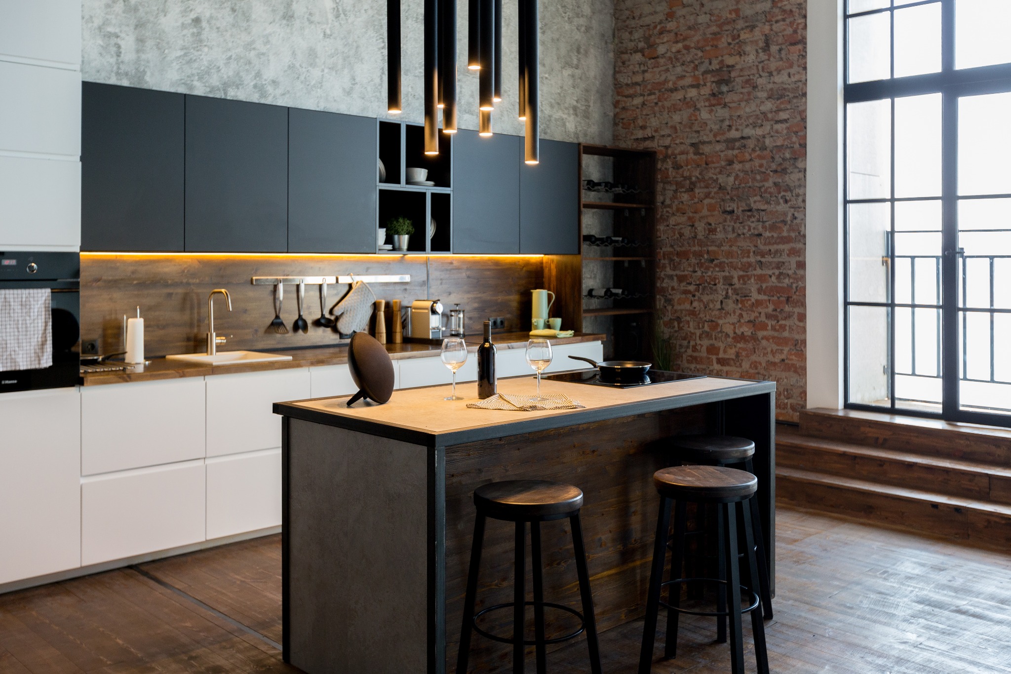 A warm and inviting looking industrial kitchen with built-in cabinets and a kitchen island.