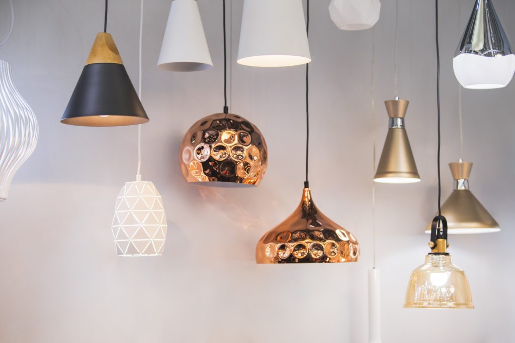 Various pendant lights of various shapes and colors that would warm up an industrial kitchen.