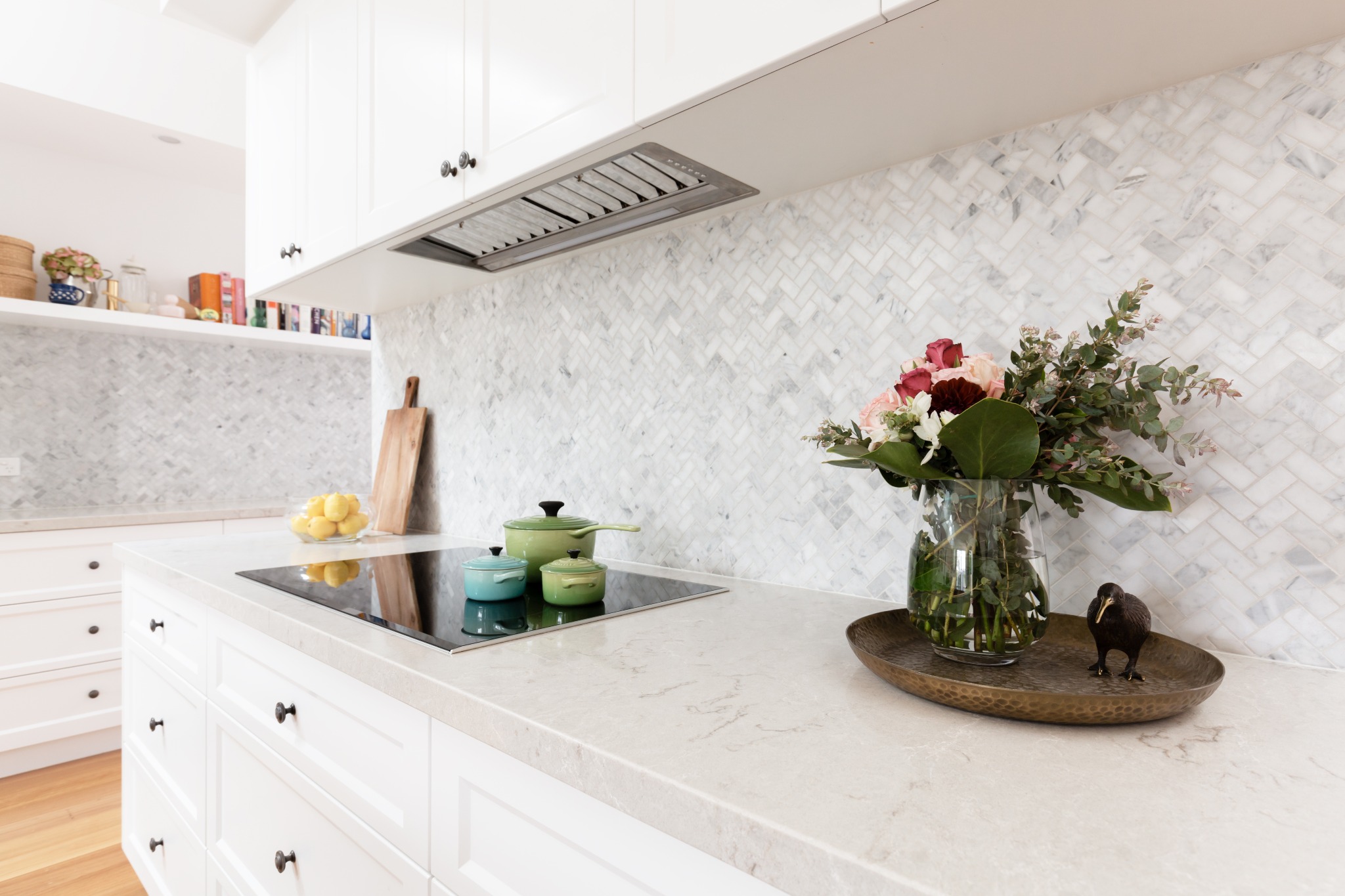 A bright white kitchen with heated counters. Styled with flowers.