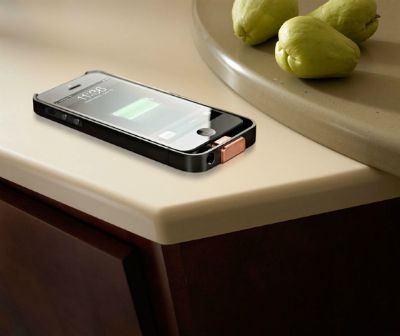 iphone sitting on a counter near some pears