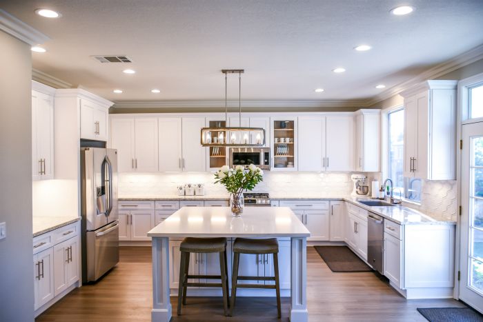 kitchen interior with white cabinets and center island with stainless steel appliences