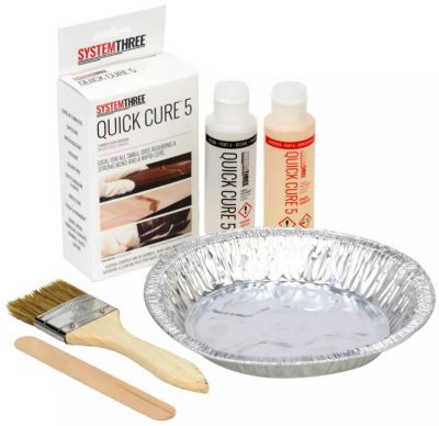 bottles and box of Quick Cure 5 brand epoxy next to aluminum pie tin and small paint brush with popsicle stick