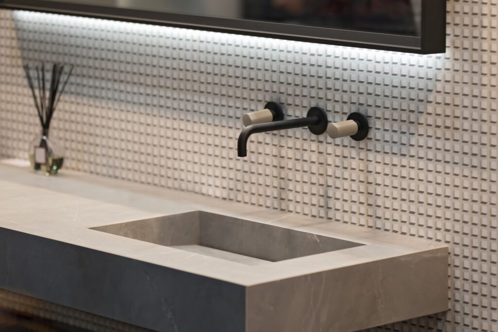 An industrial bathroom with stone countertop.A luxury guest bathroom idea is including FeelsWarm heating components.