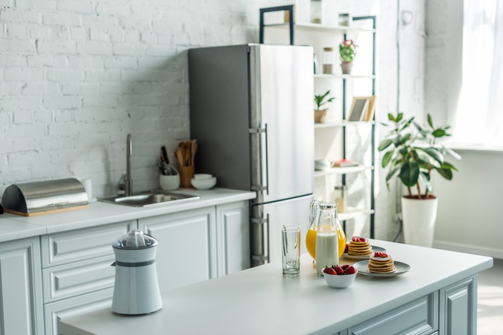 Kitchen counters that are a soft blue and match the wall paint and kitchen cabinets.