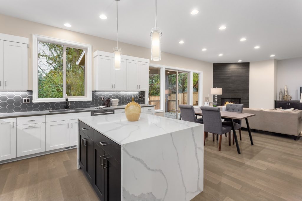 A kitchen with a granite waterfall kitchen island.