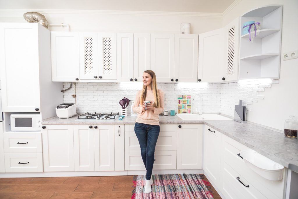 A young woman leaning on her heated stone countertops.